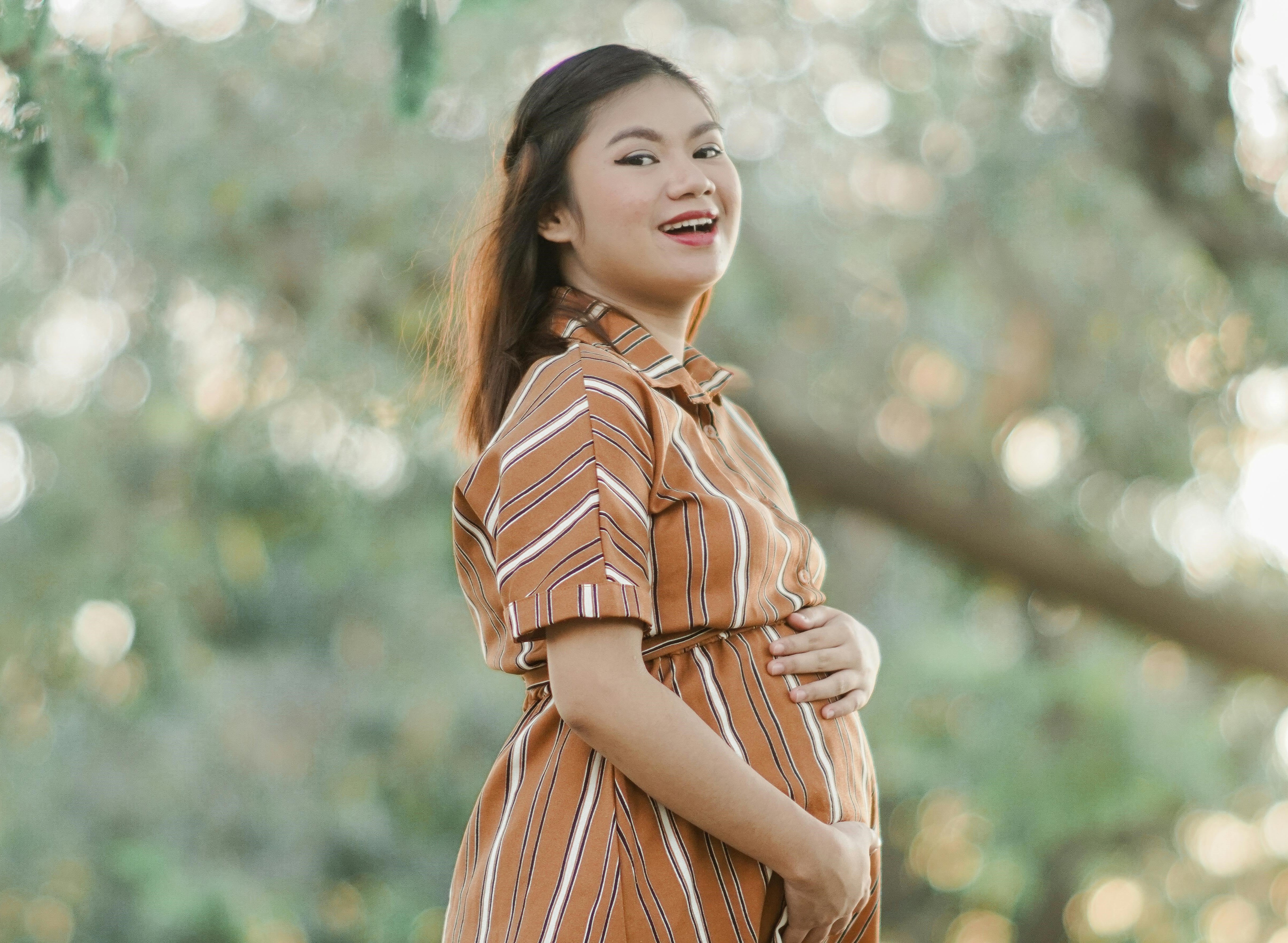 A pregnant women holding her belly with two hands